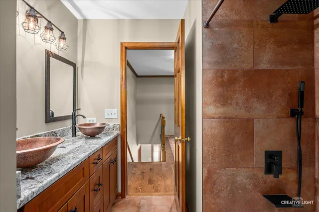 a en suite bathroom with a granite countertop sink and a mirror