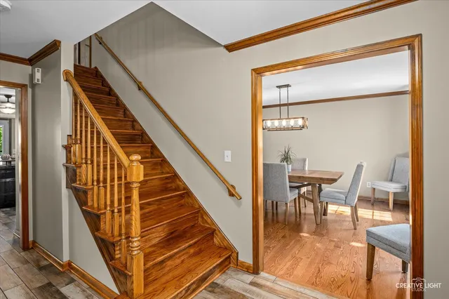 a view of a hallway with wooden floor and stairs