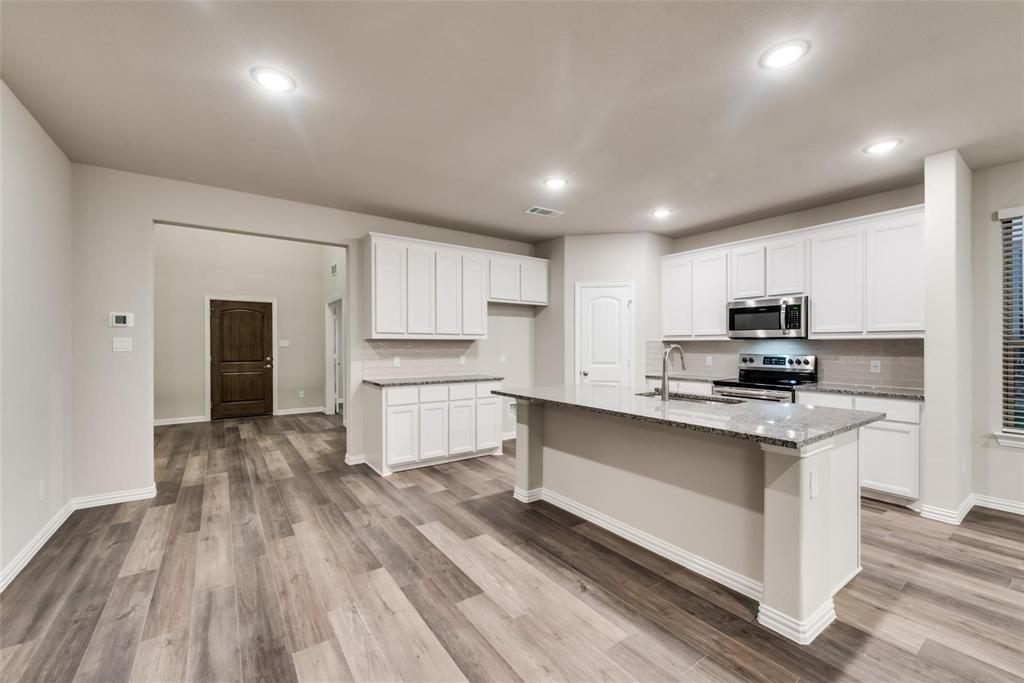 739 Copley Street Sherman, TX 75090 - Photo 8 of 31 a kitchen with stainless steel appliances granite countertop a stove top oven a sink dishwasher and a refrigerator with wooden floor