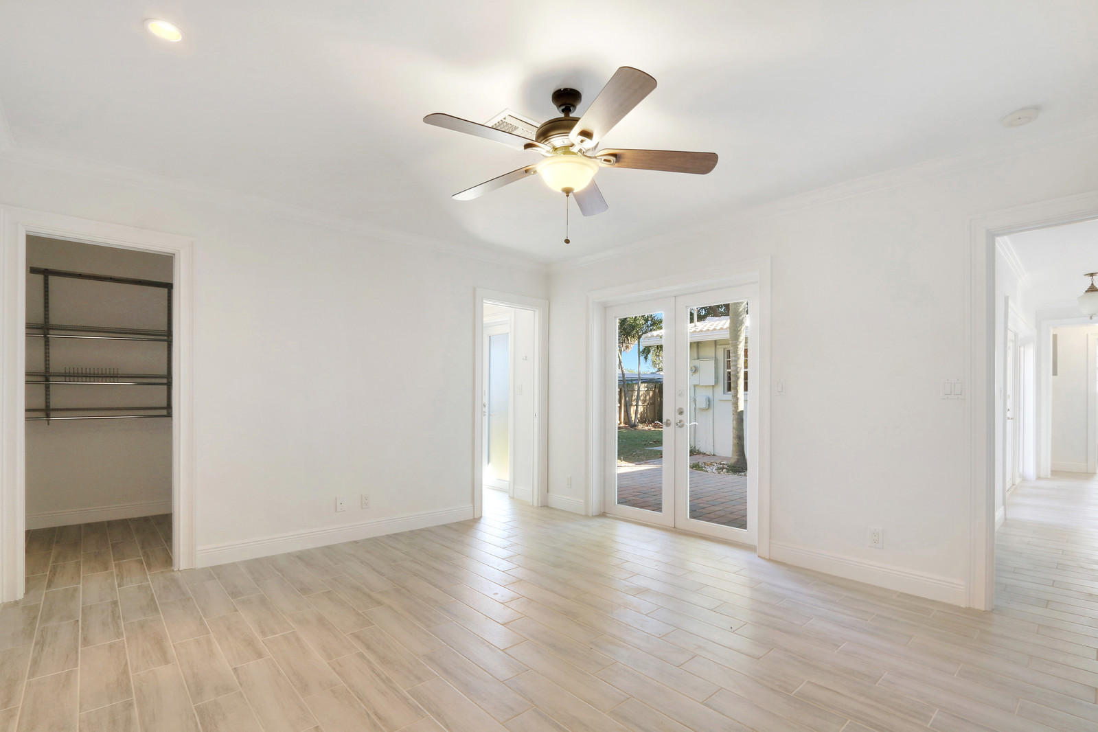 1329 Northwest 6th Street Boca Raton, FL 33486 - Photo 11 of 27 an empty room with wooden floor chandelier fan and windows