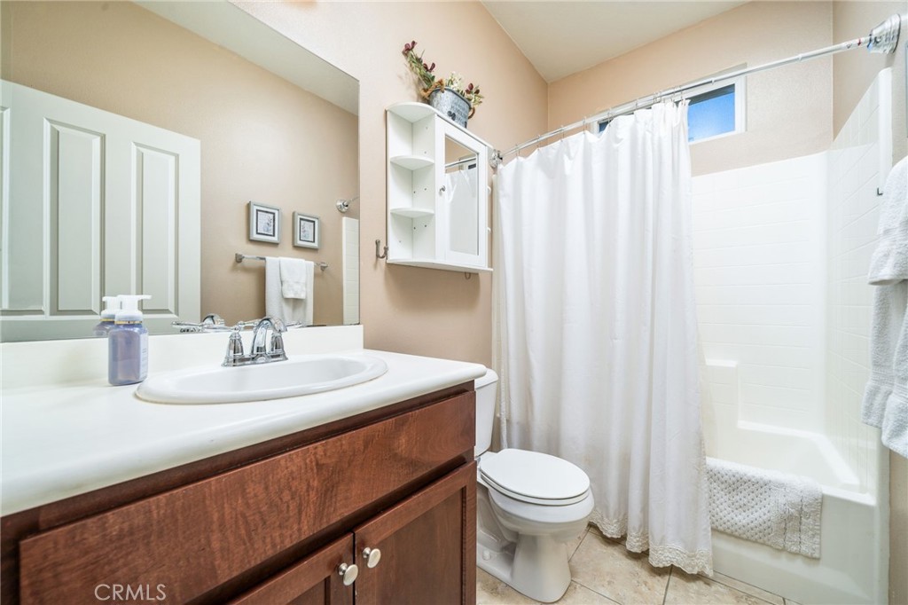 16001 Chase Road, Unit 72 Fontana, CA 92336 - Photo 17 of 43 a bathroom with a sink a toilet and shower curtain