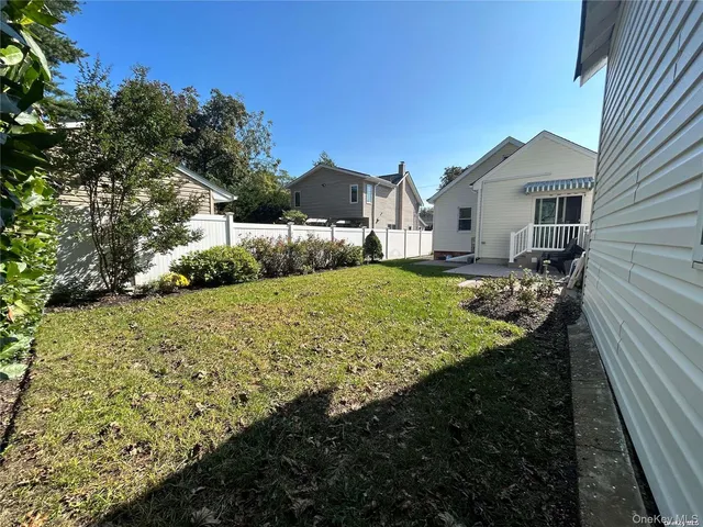 a view of a house with a big yard plants and large tree