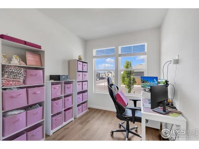 a work room with furniture a bookshelf and a window