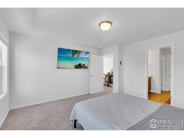 a bedroom with a bed and large windows