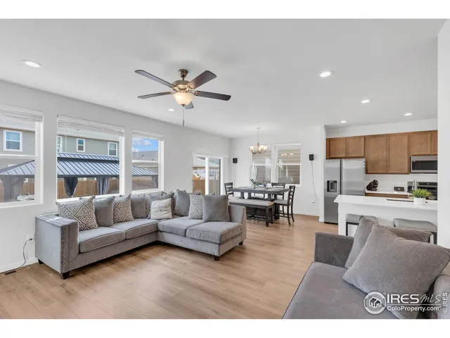 a living room with furniture kitchen view and a chandelier