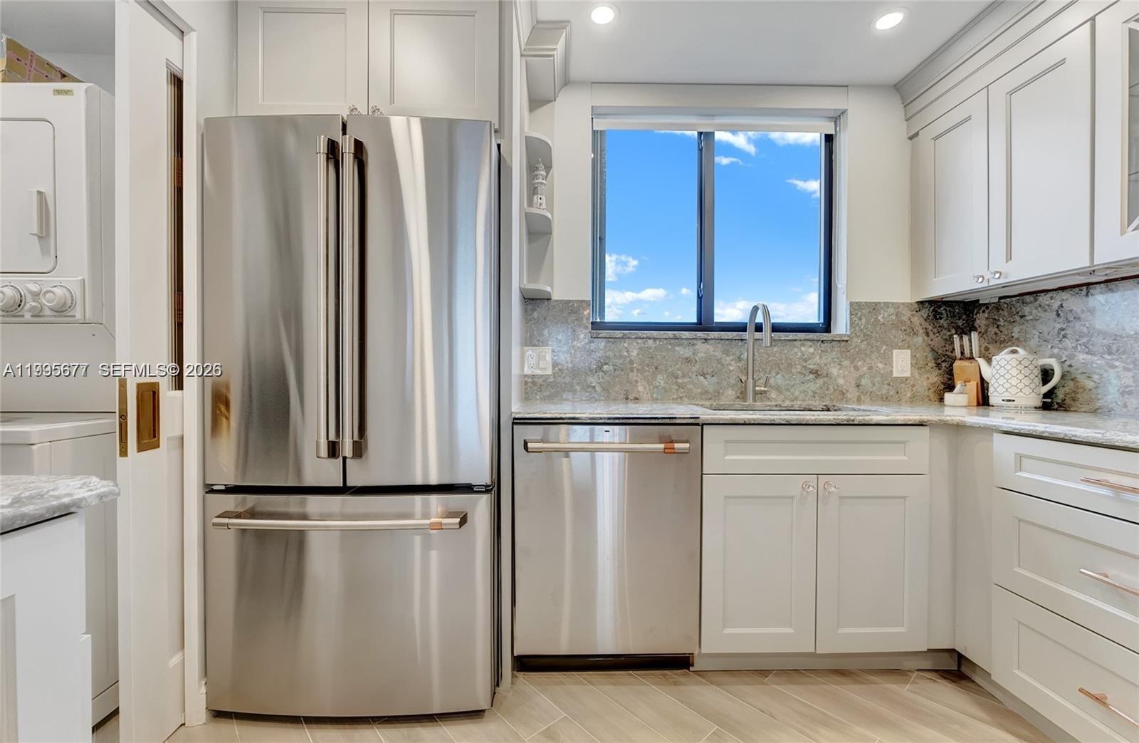 400 Ocean Trail Way, Unit 401 Jupiter, FL 33477 - Photo 11 of 28 a kitchen with stainless steel appliances granite countertop a refrigerator and a stove