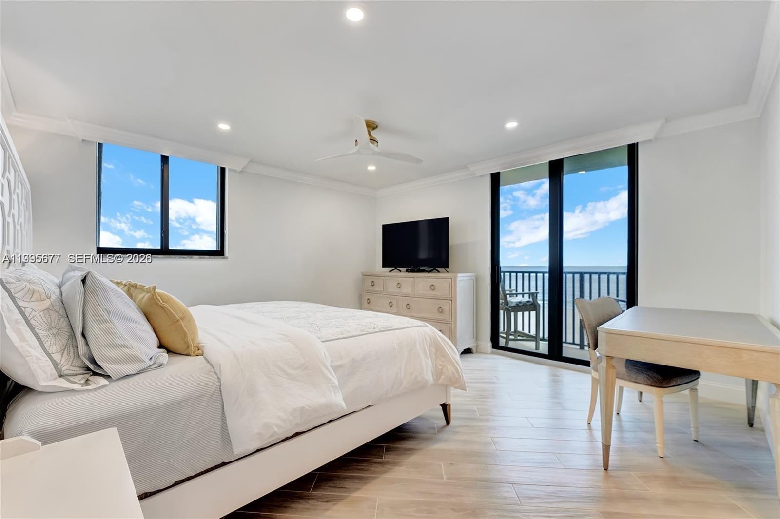400 Ocean Trail Way, Unit 401 Jupiter, FL 33477 - Photo 6 of 28 a bedroom with a bed and a flat screen tv