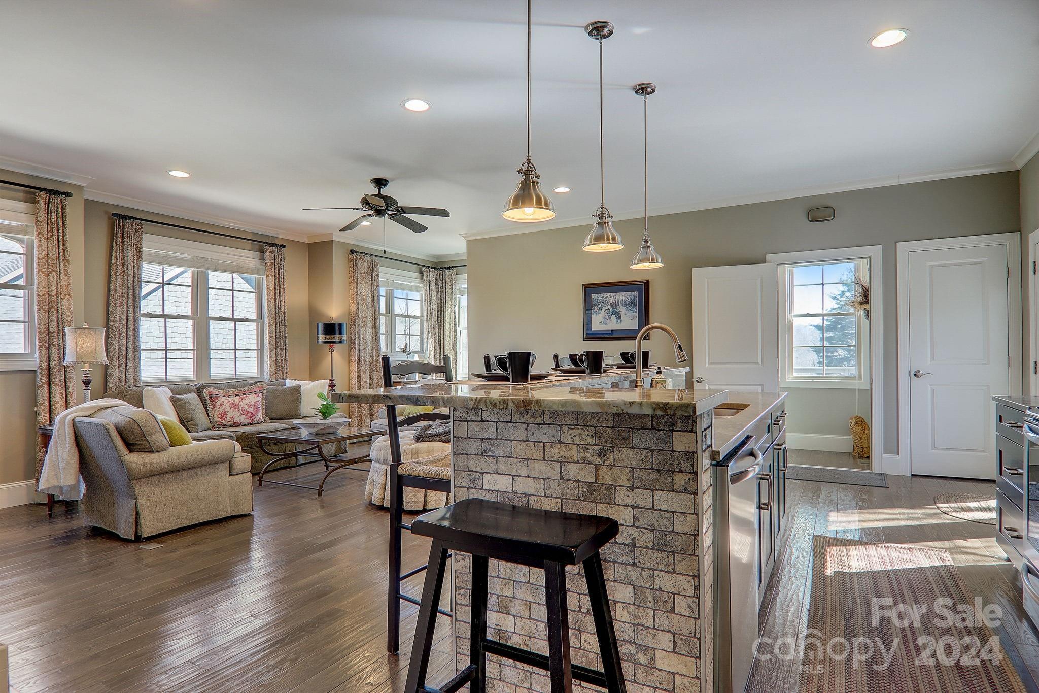 34 Ledgestone Drive Fairview, NC 28730 - Photo 42 of 47 a large living room with couches a dining table and chairs with wooden floor