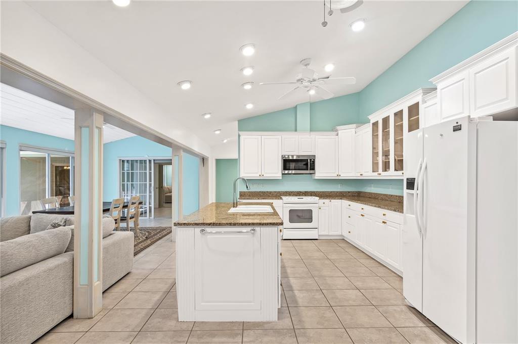 2075 Spring Place Vero Beach, FL 32963 - Photo 14 of 36 a large white kitchen with a large window and stainless steel appliances