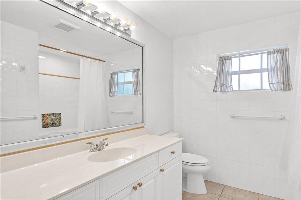 2075 Spring Place Vero Beach, FL 32963 - Photo 23 of 36 a bathroom with a sink a toilet and mirror