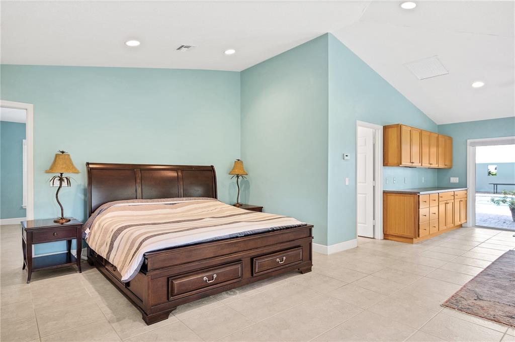 2075 Spring Place Vero Beach, FL 32963 - Photo 27 of 36 a bed sitting in a room next to a lamp