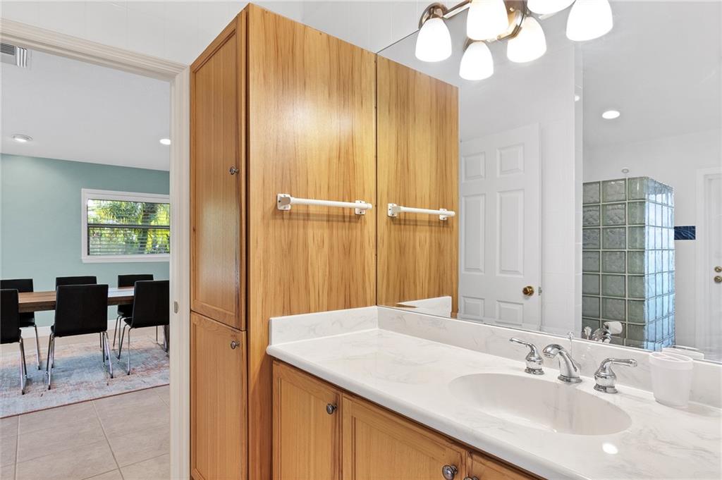 2075 Spring Place Vero Beach, FL 32963 - Photo 28 of 36 a bathroom with a sink a mirror and a shower