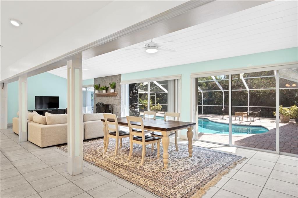 2075 Spring Place Vero Beach, FL 32963 - Photo 8 of 36 a dining room with furniture a rug and a floor to ceiling window