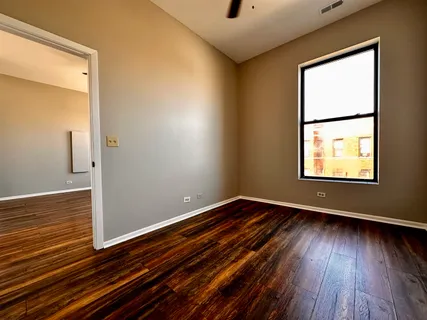 a view of an empty room with wooden floor