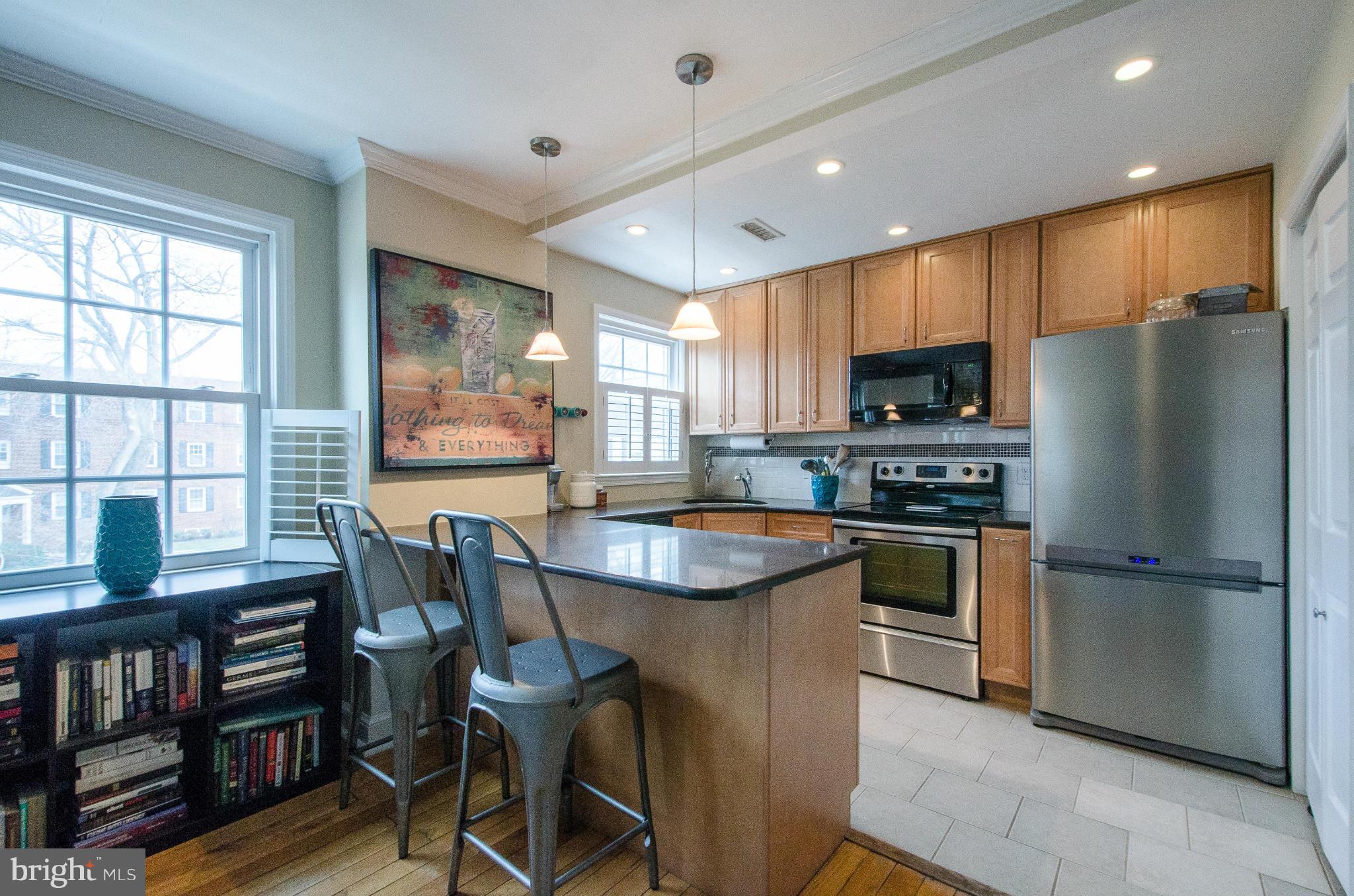 2912 13th Road South, Unit 204 Arlington, VA 22204 - Photo 6 of 13 a kitchen with kitchen island a large counter top space appliances and a window