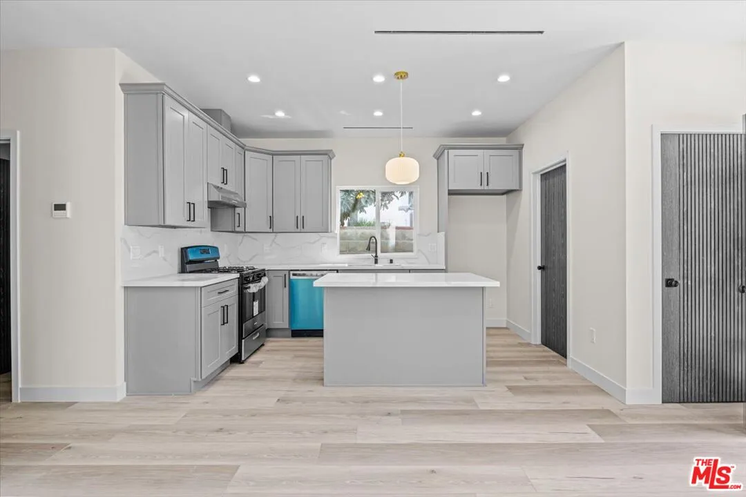a kitchen with a refrigerator and white cabinets