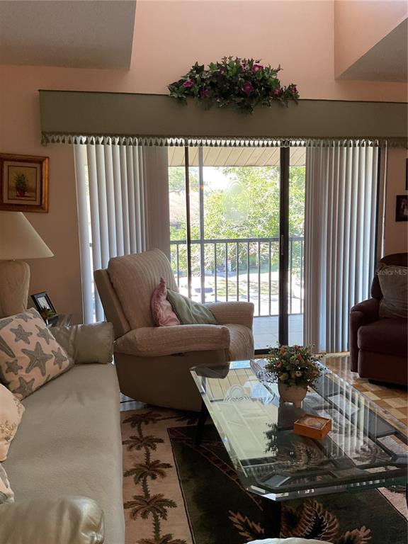 2655 Pine Ridge Way North, Unit D3 Palm Harbor, FL 34684 - Photo 7 of 31 a living room with furniture and a floor to ceiling window