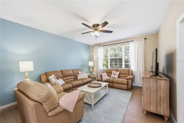 a living room with furniture a flat screen tv and a large window