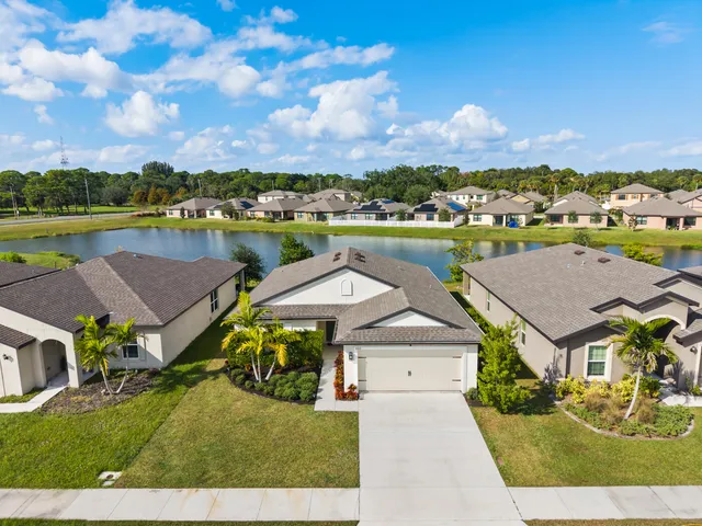 an aerial view of a house with a garden and lake view