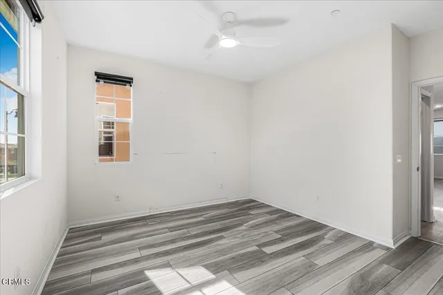 a dining hall with stainless steel appliances kitchen island granite countertop a table chairs and wooden floor