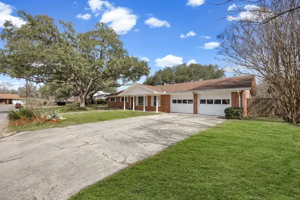 a front view of a house with yard and green space