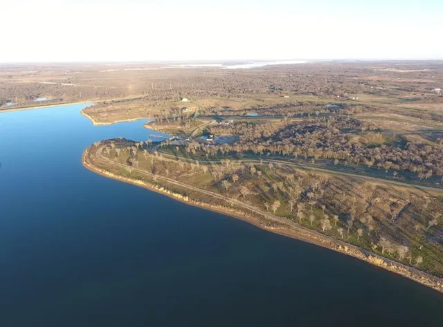 an aerial view of ocean and residential houses with outdoor space
