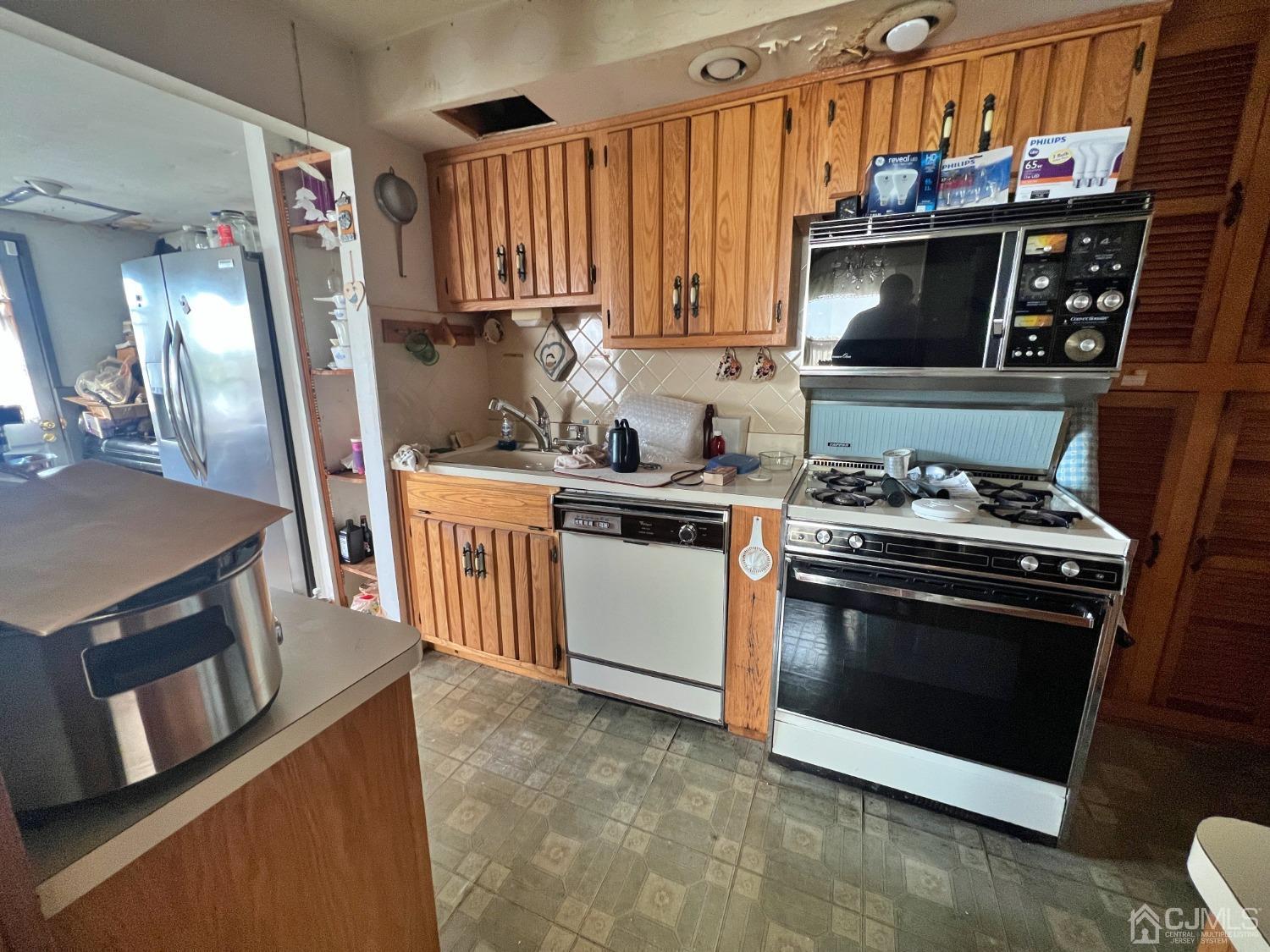 118 MacArthur Drive Edison, NJ 08837 - Photo 5 of 16 a kitchen with stainless steel appliances granite countertop a stove a sink and a refrigerator