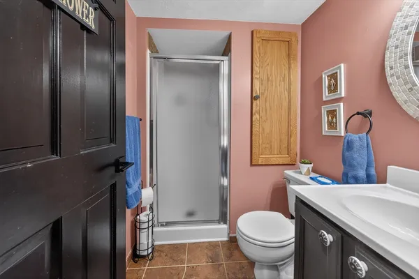 a bathroom with a granite countertop toilet sink and mirror