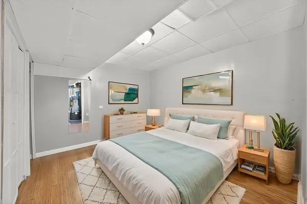 a bedroom with a large bed and a painting on the wall
