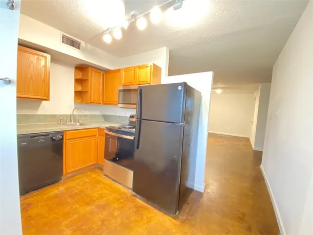a kitchen with a refrigerator sink and cabinets
