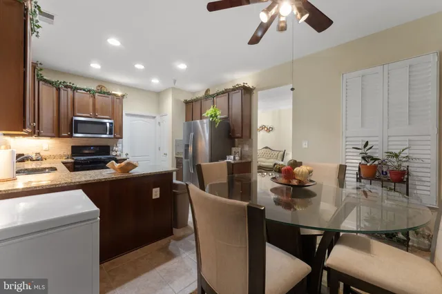 a view of a dining room with furniture and a chandelier fan