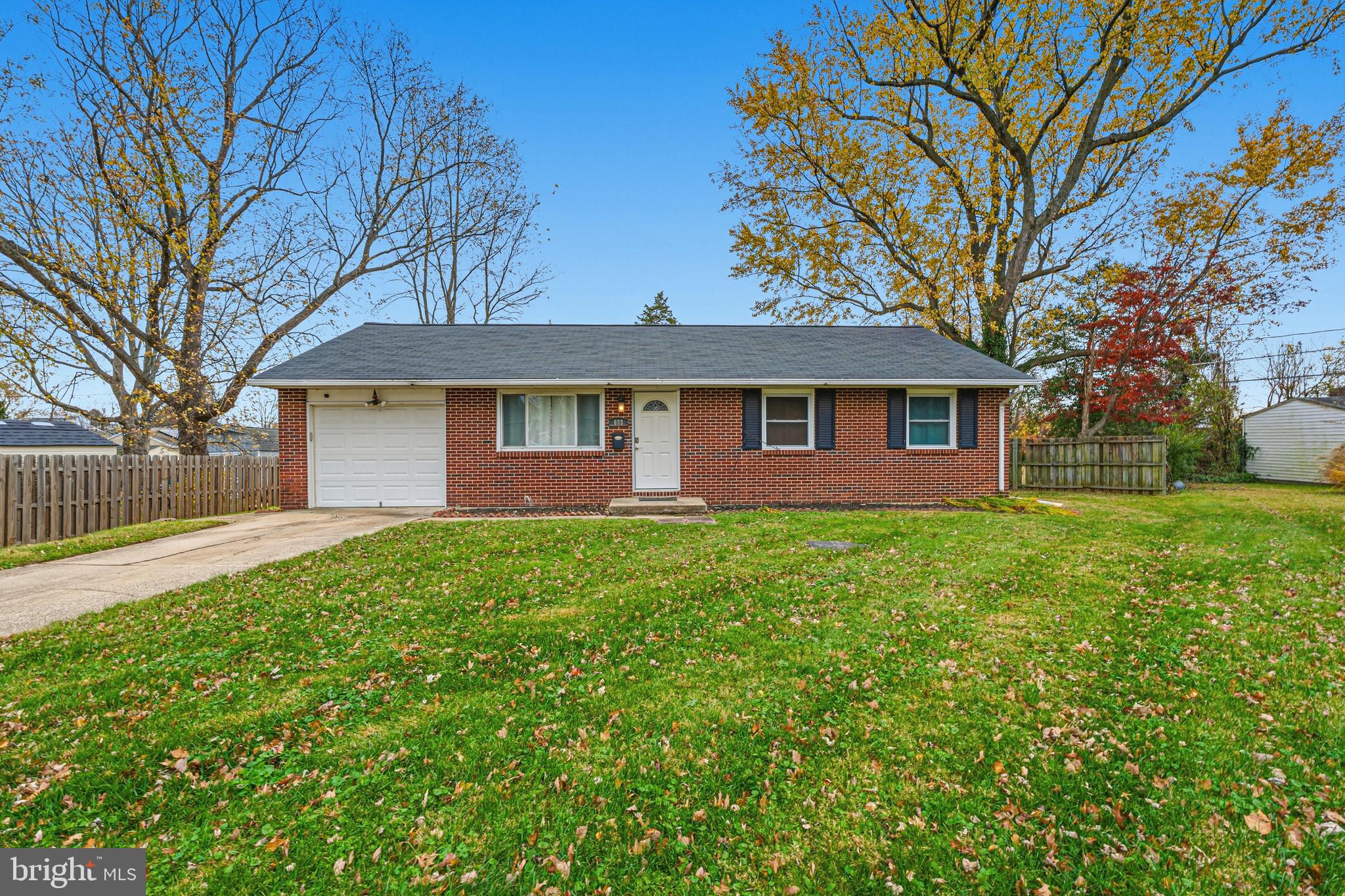 a view of a yard in front of a house with a large tree