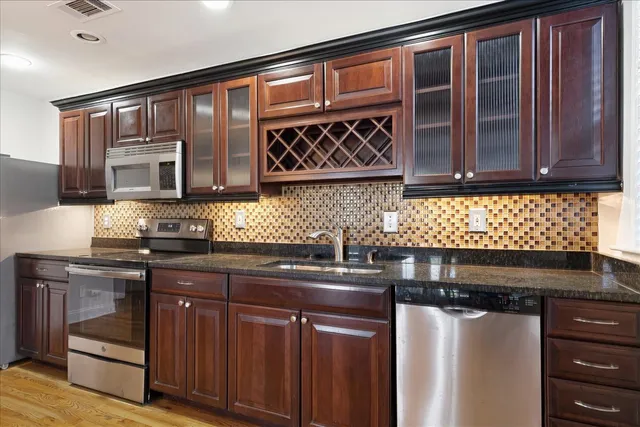 a kitchen with stainless steel appliances granite countertop a sink and cabinets