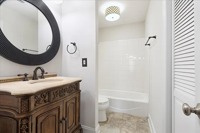 a bathroom with a granite countertop toilet a sink and a mirror