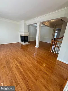 a view of empty room with wooden floor and stairs