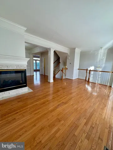 a view of a livingroom with wooden floor and a fireplace
