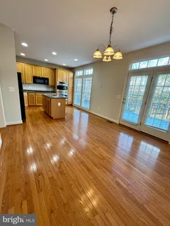 a view of a room with wooden floor and kitchen