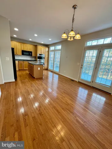 a view of a room with wooden floor and kitchen