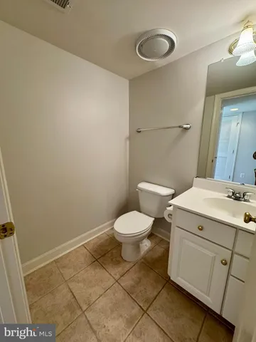 a bathroom with a granite countertop toilet and a sink