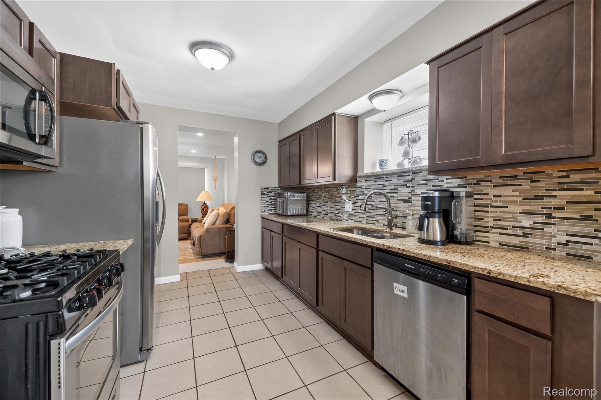 826 Goddard Road Wyandotte, MI 48192 - Photo 8 of 39 Kitchen featuring wood cabinetry, stainless steel appliances, mosaic tile backsplash, and light-toned countertops
