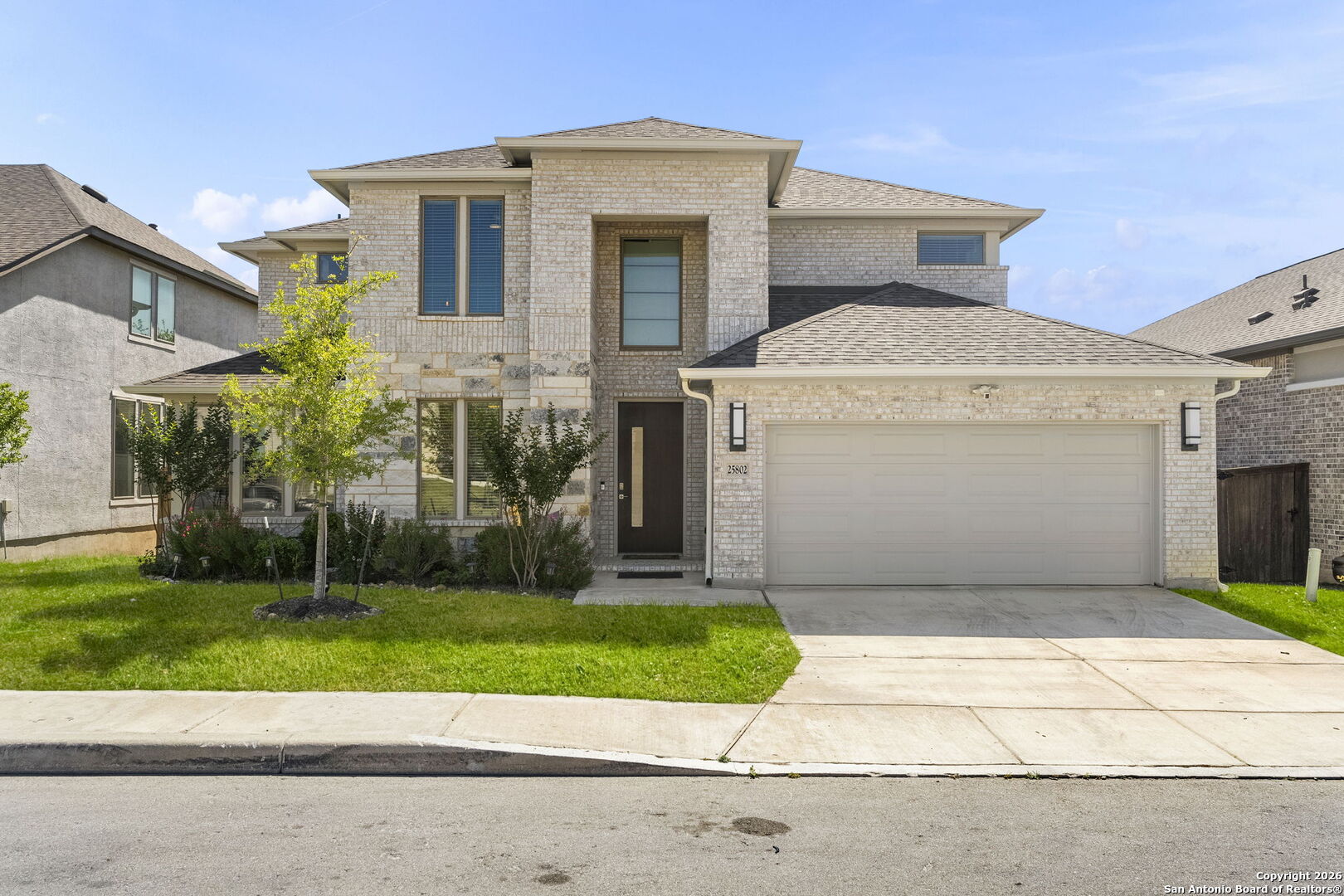 a front view of a house with a garden and garage