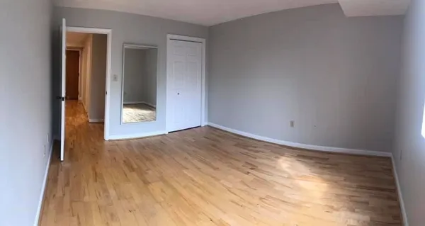a view of empty room with wooden floor