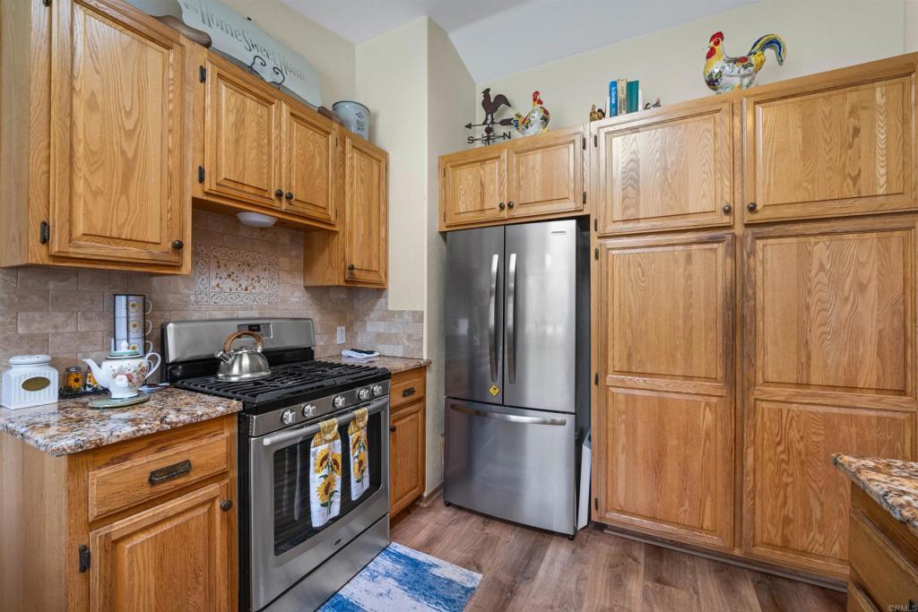13995 Whispering Meadows Lane Jamul, CA 91935 - Photo 18 of 62 a kitchen with stainless steel appliances granite countertop a refrigerator stove and microwave
