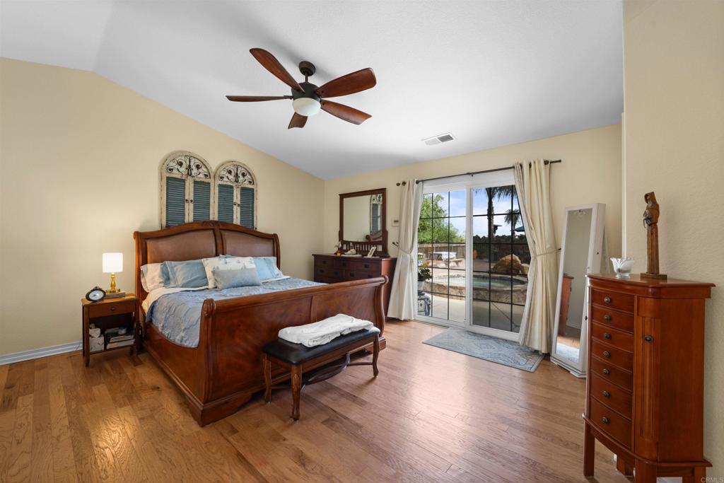 13995 Whispering Meadows Lane Jamul, CA 91935 - Photo 29 of 62 a spacious bedroom with a bed a dresser and a large window