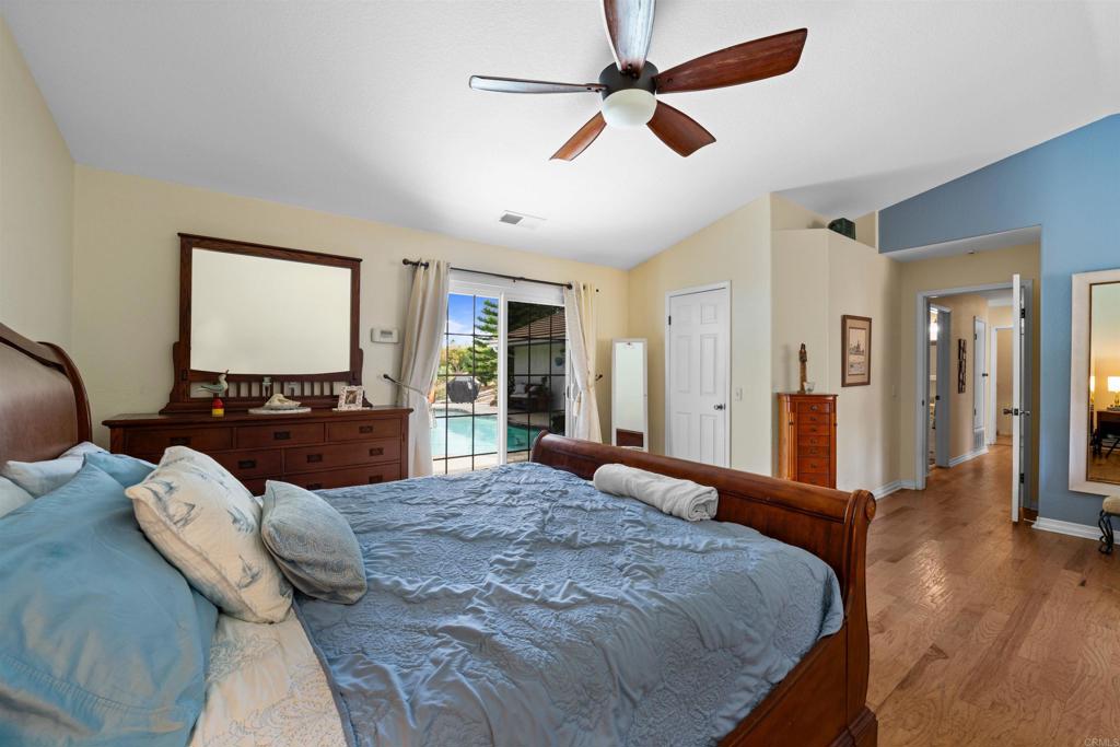 13995 Whispering Meadows Lane Jamul, CA 91935 - Photo 30 of 62 a large bedroom with wooden floor fan and windows