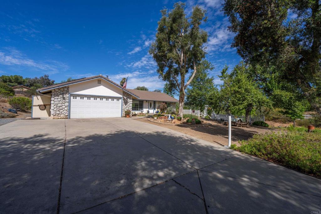 13995 Whispering Meadows Lane Jamul, CA 91935 - Photo 39 of 62 a front view of a house with a yard and garage