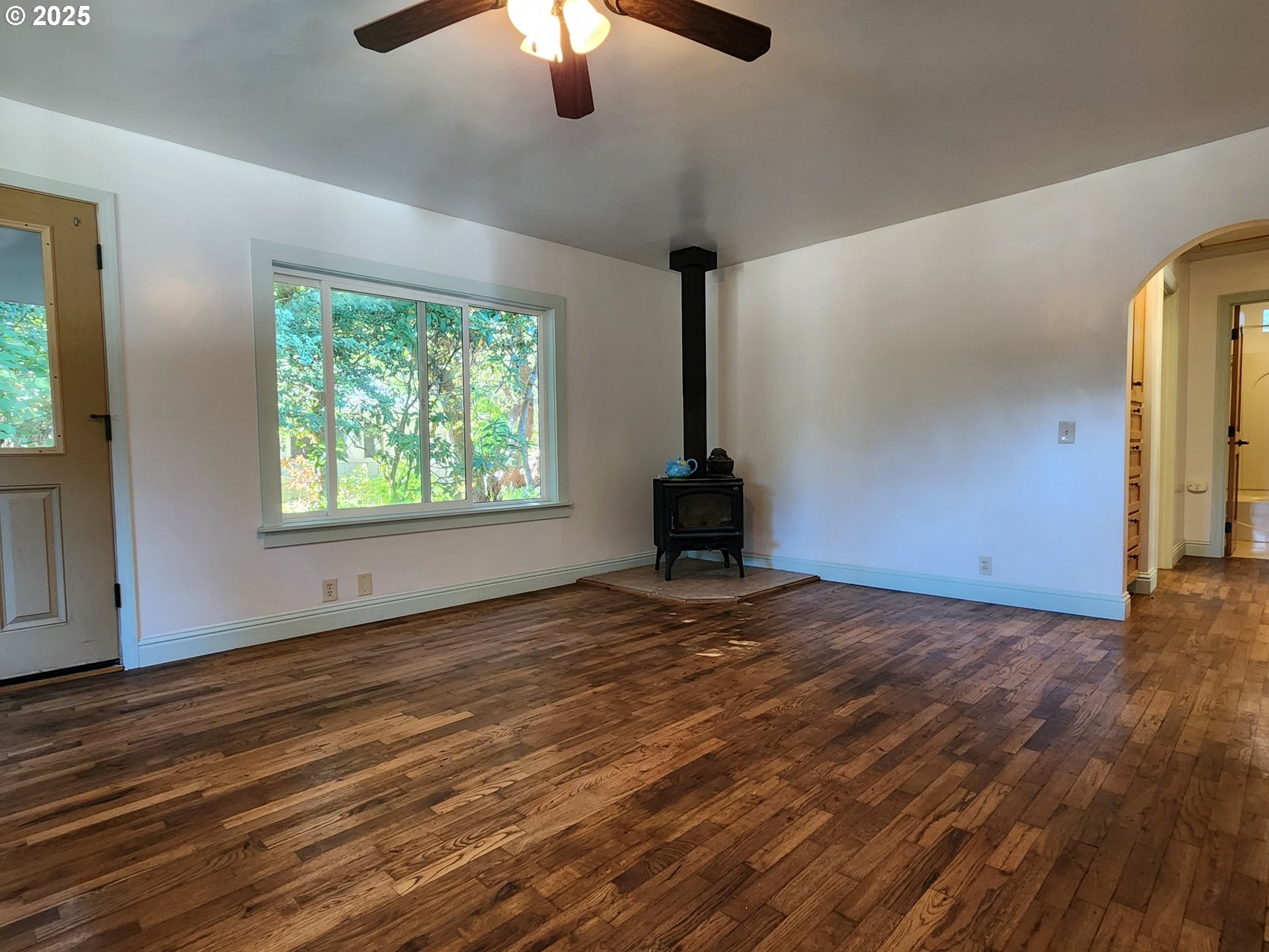 636 18th Street Port Orford, OR 97465 - Photo 12 of 29 a view of an empty room with window a ceiling fan and wooden floor