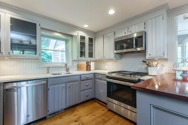 a kitchen with stainless steel appliances granite countertop wooden cabinets stove top oven and sink