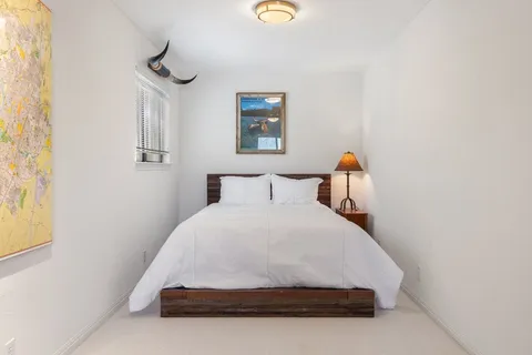 a large bed sitting in a bedroom next to a window
