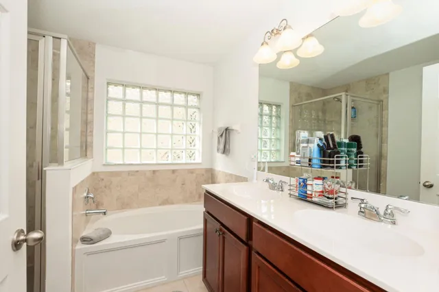 a bathroom with a tub sink and mirror